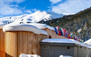 Invloed van Davos op Europese aandelen - , Zwitserland: houten paviljoens met sneeuw en rijen nationale vlaggen voor het World Economic Forum