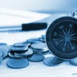 Kompas tussen stapeltjes munten symboliseert richting zoeken bij beleggen op de beurs