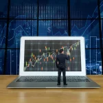 Beleggen automatiseren met professionele desktopsoftware, man analyseert grafieken op groot scherm